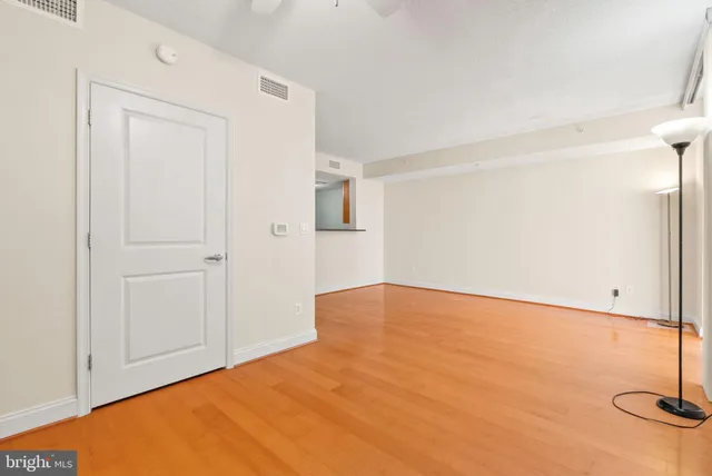 a view of empty room with wooden floor