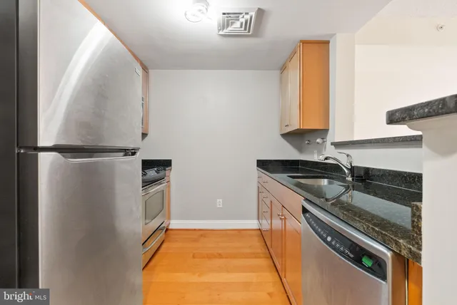 a kitchen with granite countertop a stove and a refrigerator