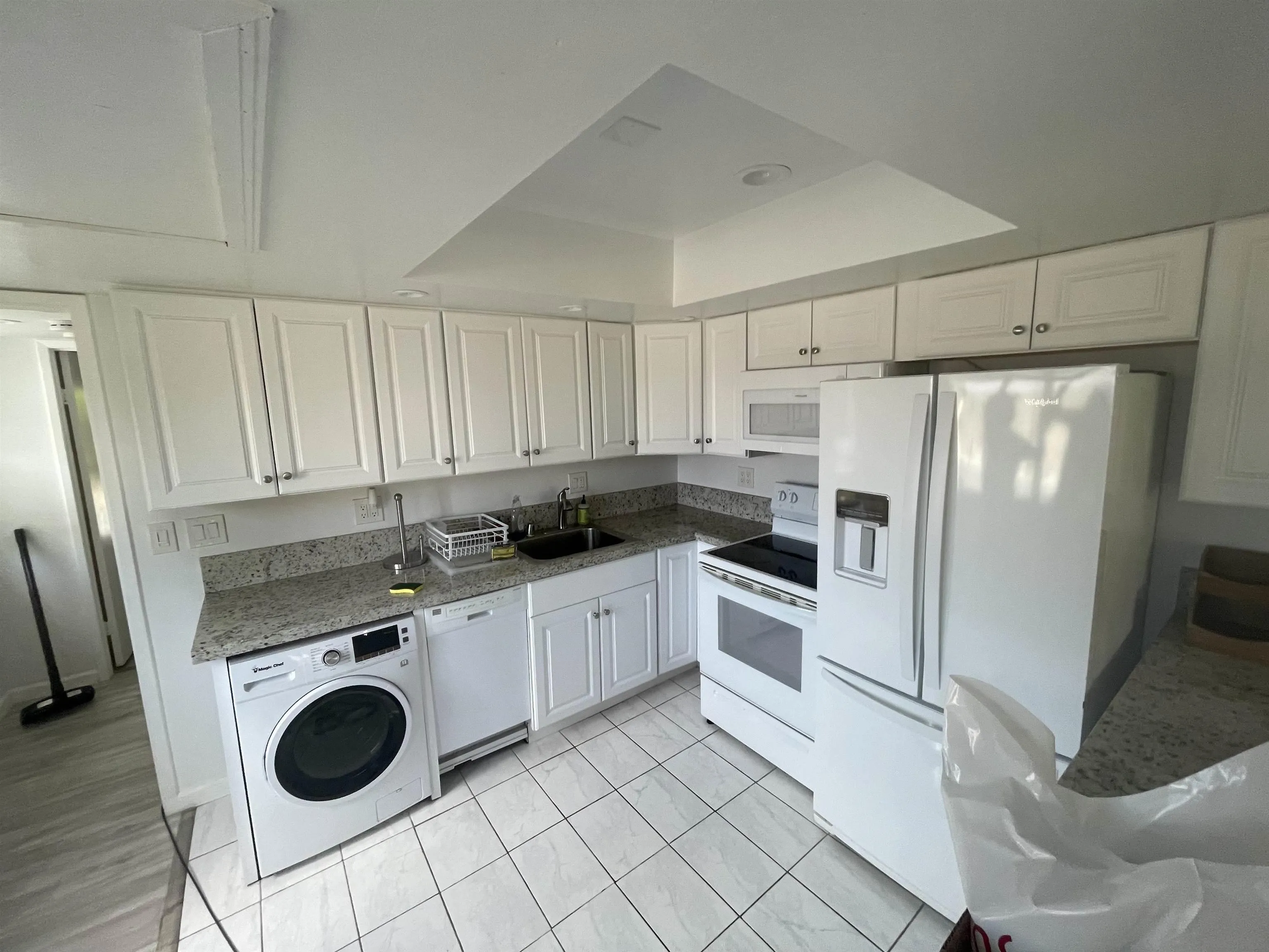 a kitchen with white cabinets and white appliances
