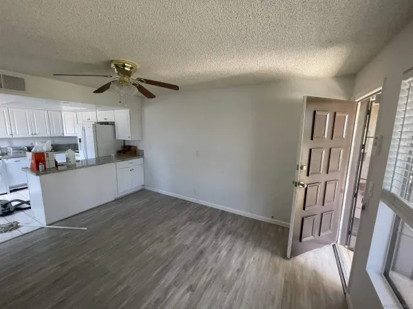 a view of a kitchen with a sink fridge and wooden floor