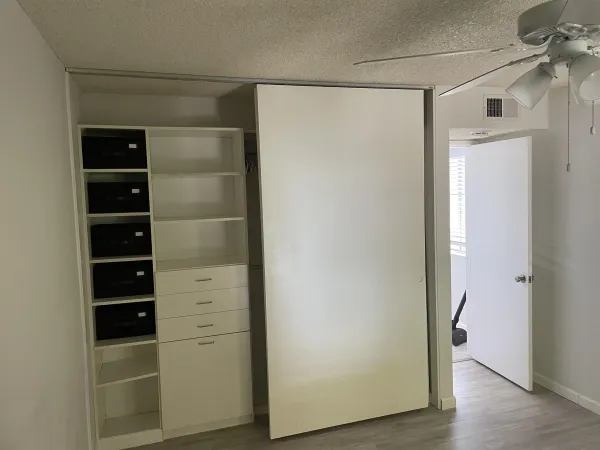 a view of walk in closet with empty racks