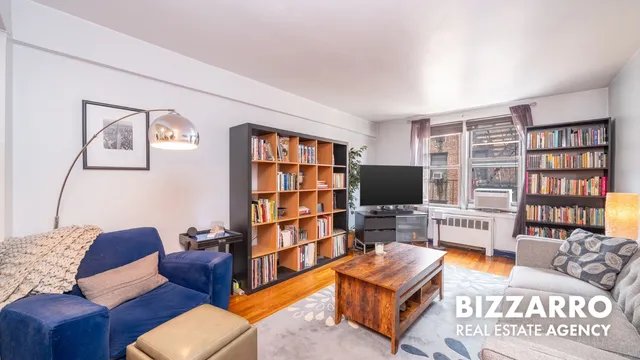 a living room with furniture a bookshelf and a flat screen tv