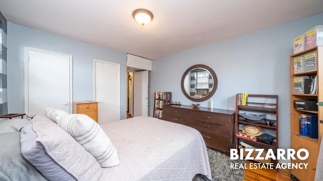 a bed room with a bed a clock and a bookshelf