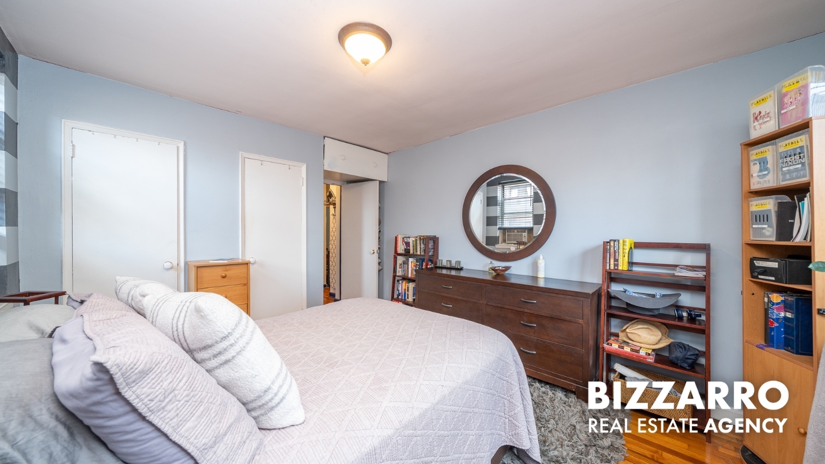 Undisclosed Address Manhattan, NY 10040 - Photo 12 of 14 a bed room with a bed a clock and a bookshelf