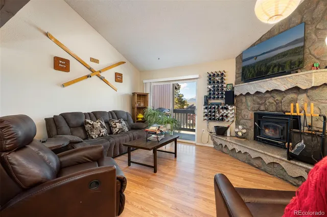 a living room with furniture a fireplace a flat screen tv and potted plant