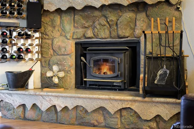 a living room with a fireplace wooden floor and a table