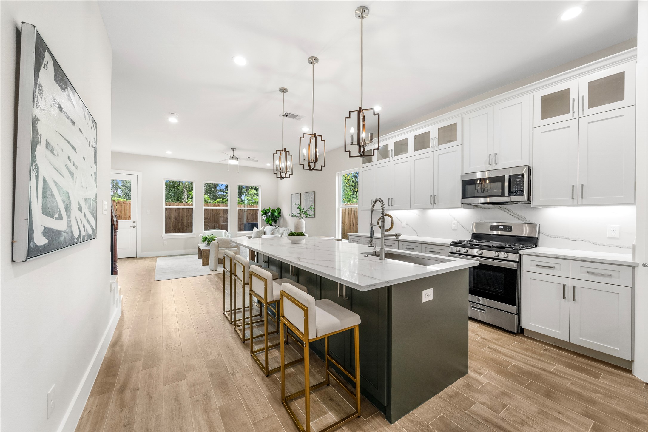 a kitchen with stainless steel appliances granite countertop a sink a stove and a wooden floors