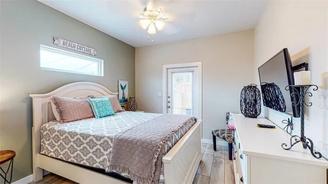 a bedroom with a bed and a flat tv screen on the dresser