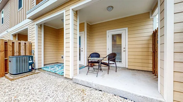a view of a patio with a table and chairs and wooden fence