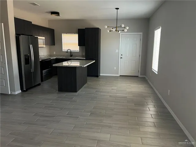 a large kitchen with a refrigerator and a stove top oven