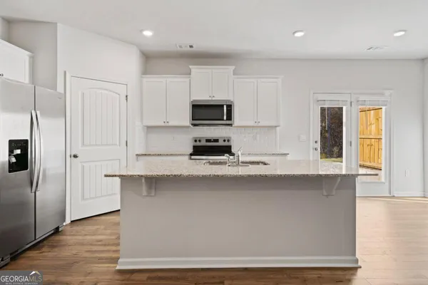 a kitchen with stainless steel appliances granite countertop a stove a sink and a refrigerator