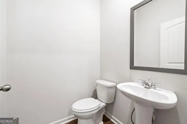 a bathroom with a sink a toilet and mirror