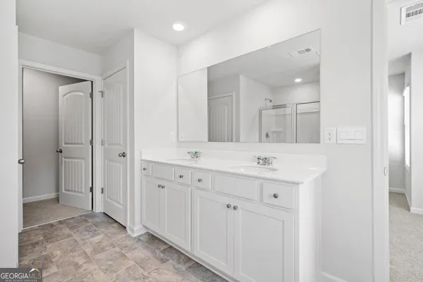 a bathroom with a double vanity sink and a mirror