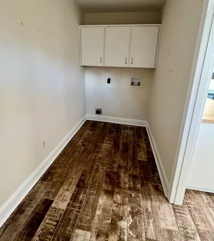 a room with wooden floor and white walls