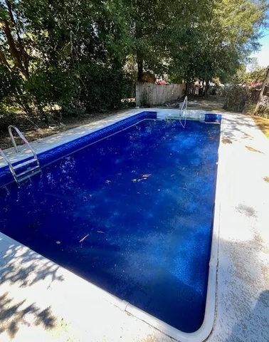a view of a yard with wooden fence