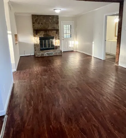 a view of a livingroom with wooden floor and a fireplace