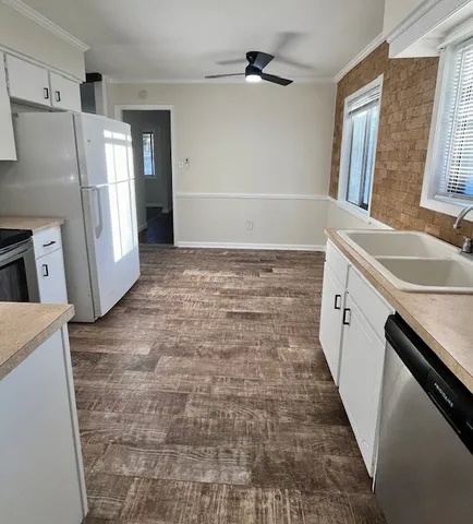 a bathroom with a granite countertop sink a toilet a refrigerator a vanity and a mirror