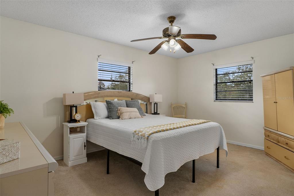 2300 Restmere Lane Spring Hill, FL 34609 - Photo 12 of 28 a bedroom with a bed and a chandelier