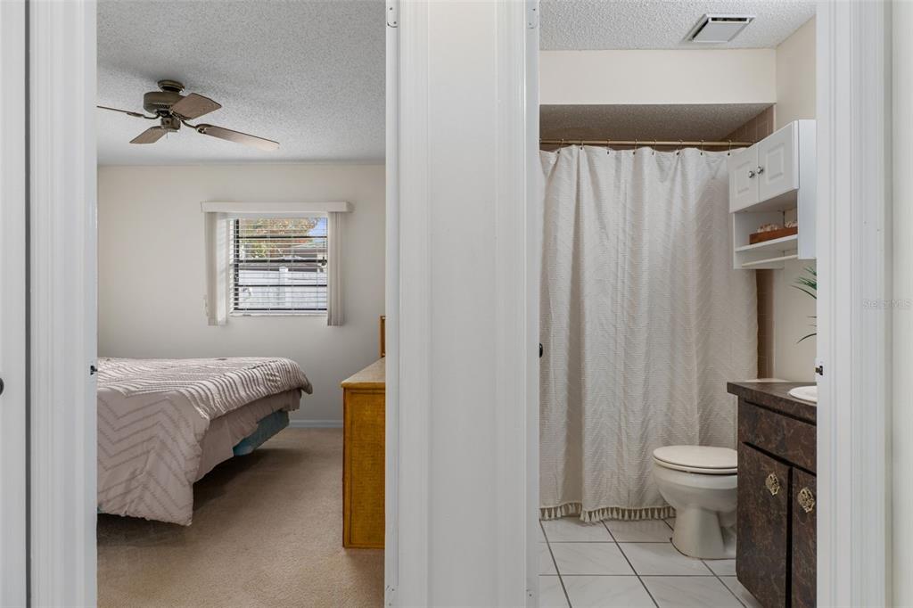 2300 Restmere Lane Spring Hill, FL 34609 - Photo 16 of 28 a bedroom with a bed and a chandelier
