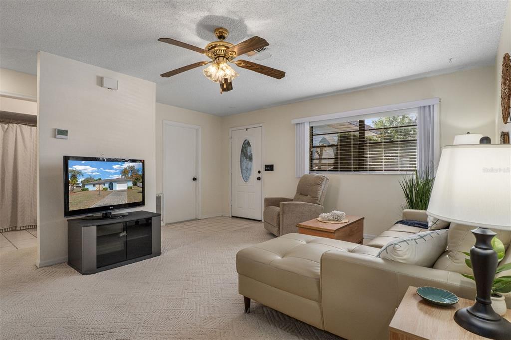 2300 Restmere Lane Spring Hill, FL 34609 - Photo 6 of 28 a living room with furniture and a flat screen tv