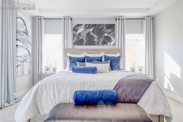 a bedroom with a large bed and a painting on the wall