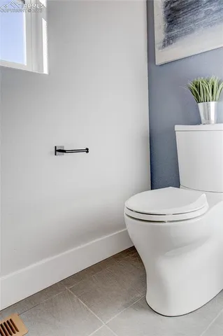 a white toilet sitting next to a white cabinet