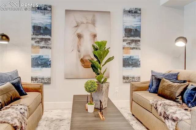 a living room with furniture flowerpot and wooden floor