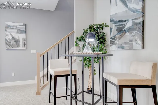 a kitchen with stainless steel appliances granite countertop a sink a stove top oven a dining table and chairs with wooden floor