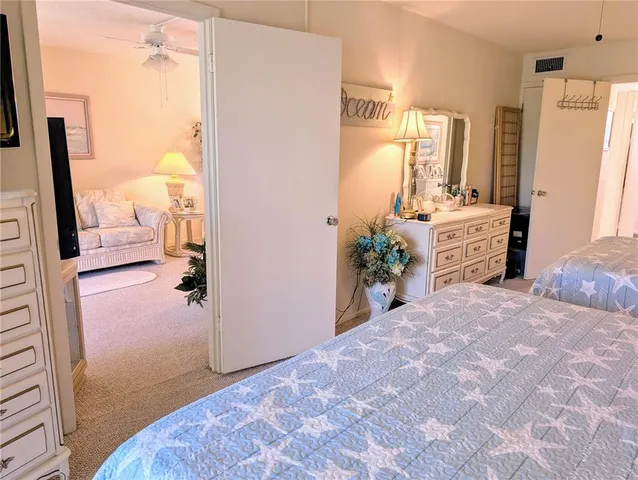 a bedroom with a bed dresser and a large mirror