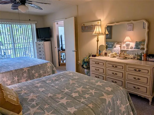a bedroom with a bed and a flat tv screen on dresser