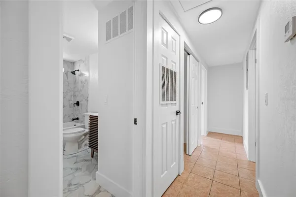 a view of a hallway with closet and wooden floor