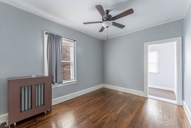 4820 West Wolfram Street, Unit 2 Chicago, IL 60641 - Photo 14 of 17 wooden floor in an empty room with a window