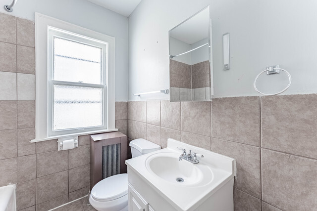 4820 West Wolfram Street, Unit 2 Chicago, IL 60641 - Photo 8 of 17 a bathroom with a sink toilet and mirror