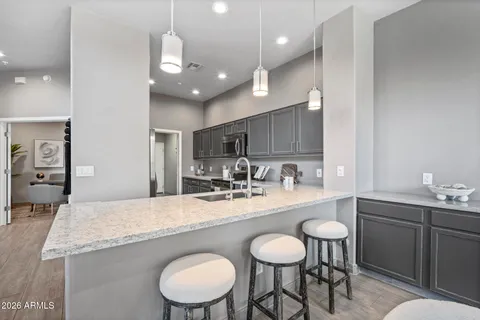 a kitchen with granite countertop a table chairs stove and sink