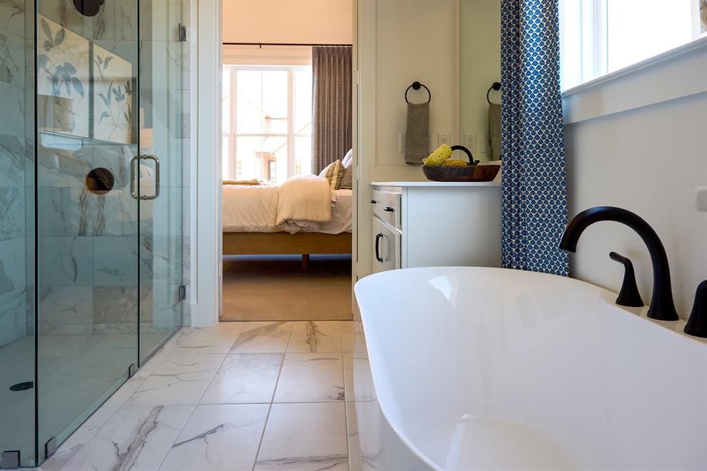 651 Caprice Bluff Fate, TX 75189 - Photo 13 of 26 a bedroom with a bed and a dresser next to a window