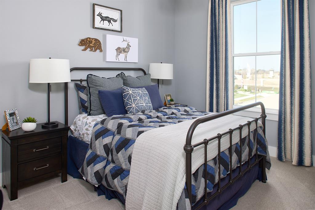 651 Caprice Bluff Fate, TX 75189 - Photo 17 of 26 a bedroom with a bed and a lamp on table