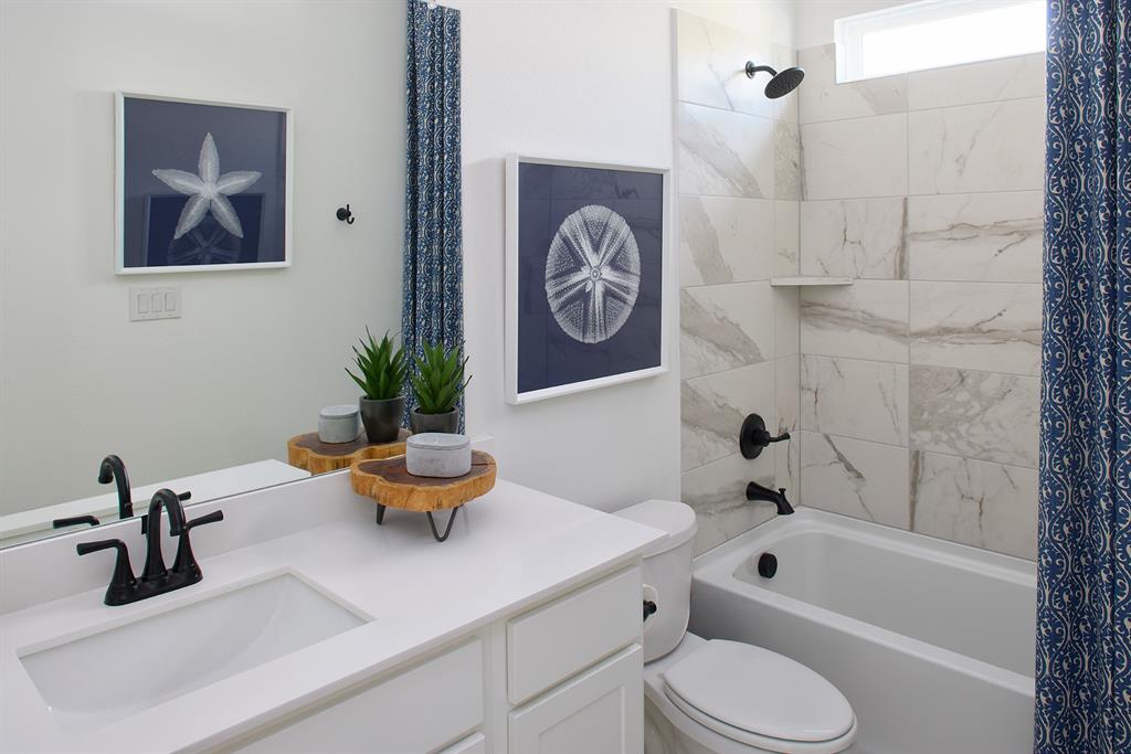 651 Caprice Bluff Fate, TX 75189 - Photo 18 of 26 a bathroom with a toilet a sink and a bathtub