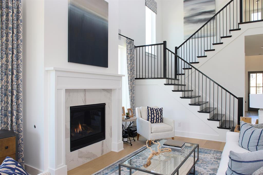 651 Caprice Bluff Fate, TX 75189 - Photo 4 of 26 a living room with wooden floor and a fireplace