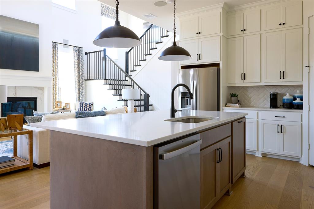 651 Caprice Bluff Fate, TX 75189 - Photo 25 of 26 a kitchen with stainless steel appliances a sink a stove and a wooden floor