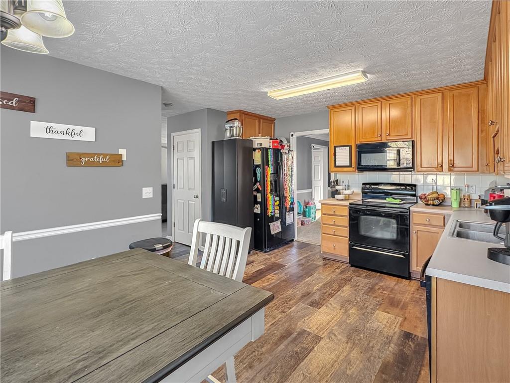 637 Sleeping Meadow Lane Bethlehem, GA 30620 - Photo 5 of 12 a kitchen with granite countertop a stove top oven and refrigerator