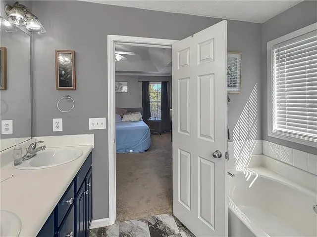a en suite bathroom with a tub sink and mirror