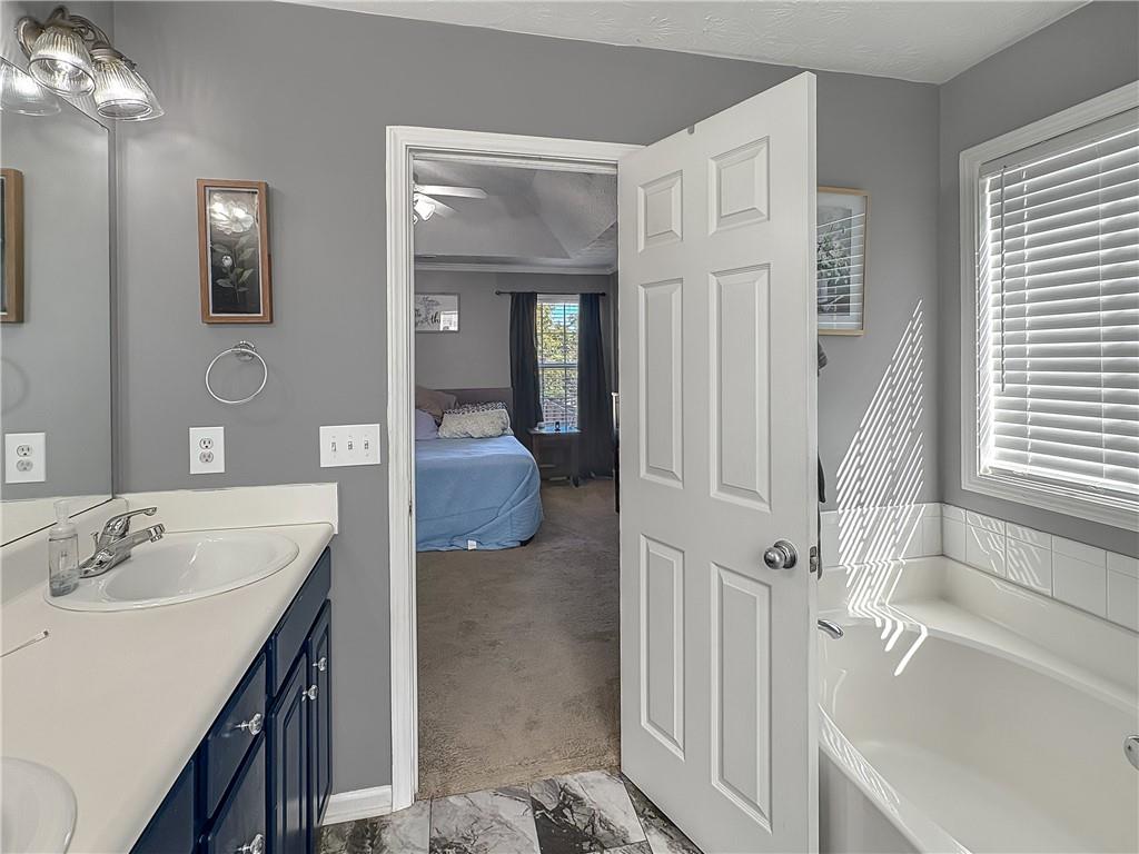 637 Sleeping Meadow Lane Bethlehem, GA 30620 - Photo 8 of 12 a en suite bathroom with a tub sink and mirror