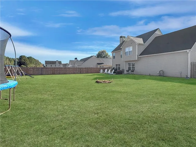 a backyard of a house with table and chairs