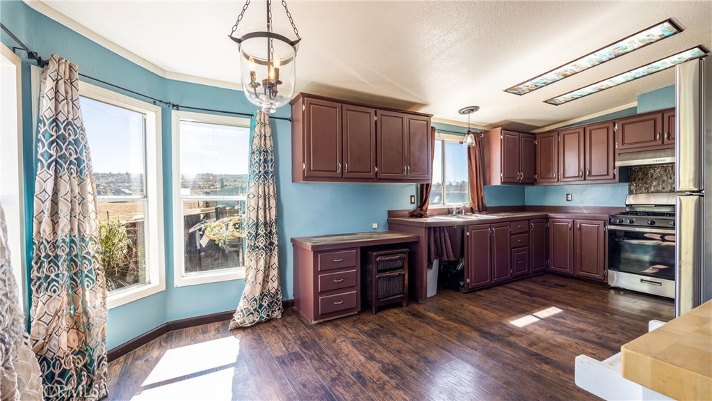 39550 Kirby Road Anza, CA 92539 - Photo 14 of 51 a kitchen with stainless steel appliances granite countertop a refrigerator a sink dishwasher a stove and a dining table with wooden floor