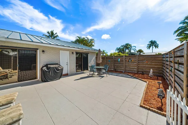 a view of a patio with table and chairs with wooden fence