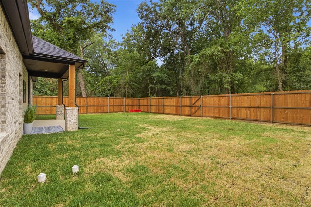 429 Waterboard Road Trinidad, TX 75163 - Photo 23 of 25 Expansive backyard featuring a new wood privacy fence, a covered patio with brick and wood columns, and ample green space