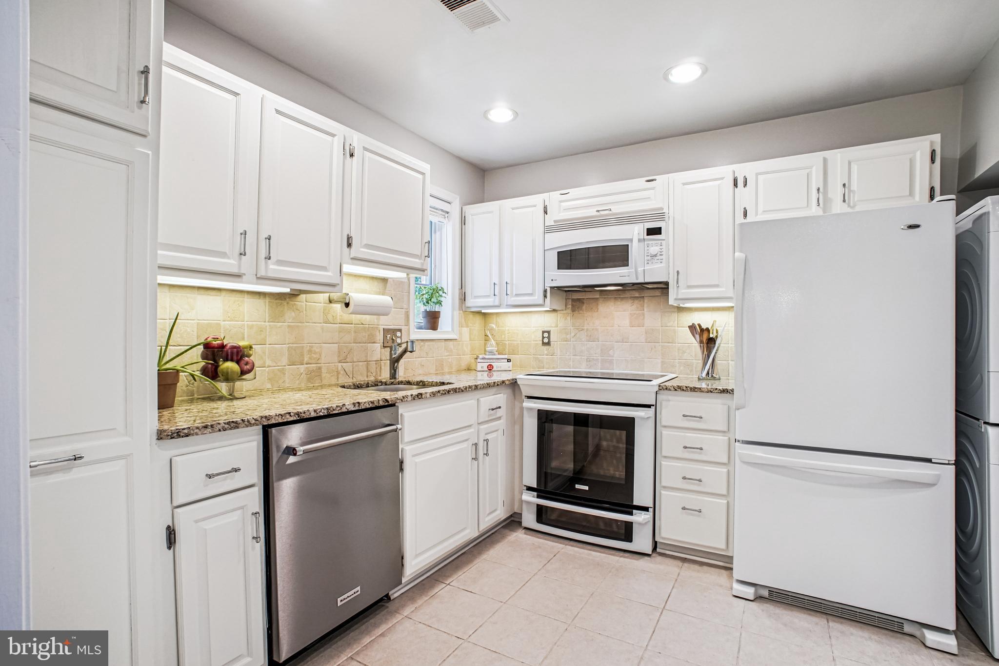 6719 Fairfax Road, Unit 67 Chevy Chase, MD 20815 - Photo 11 of 24 a kitchen with white cabinets and white appliances