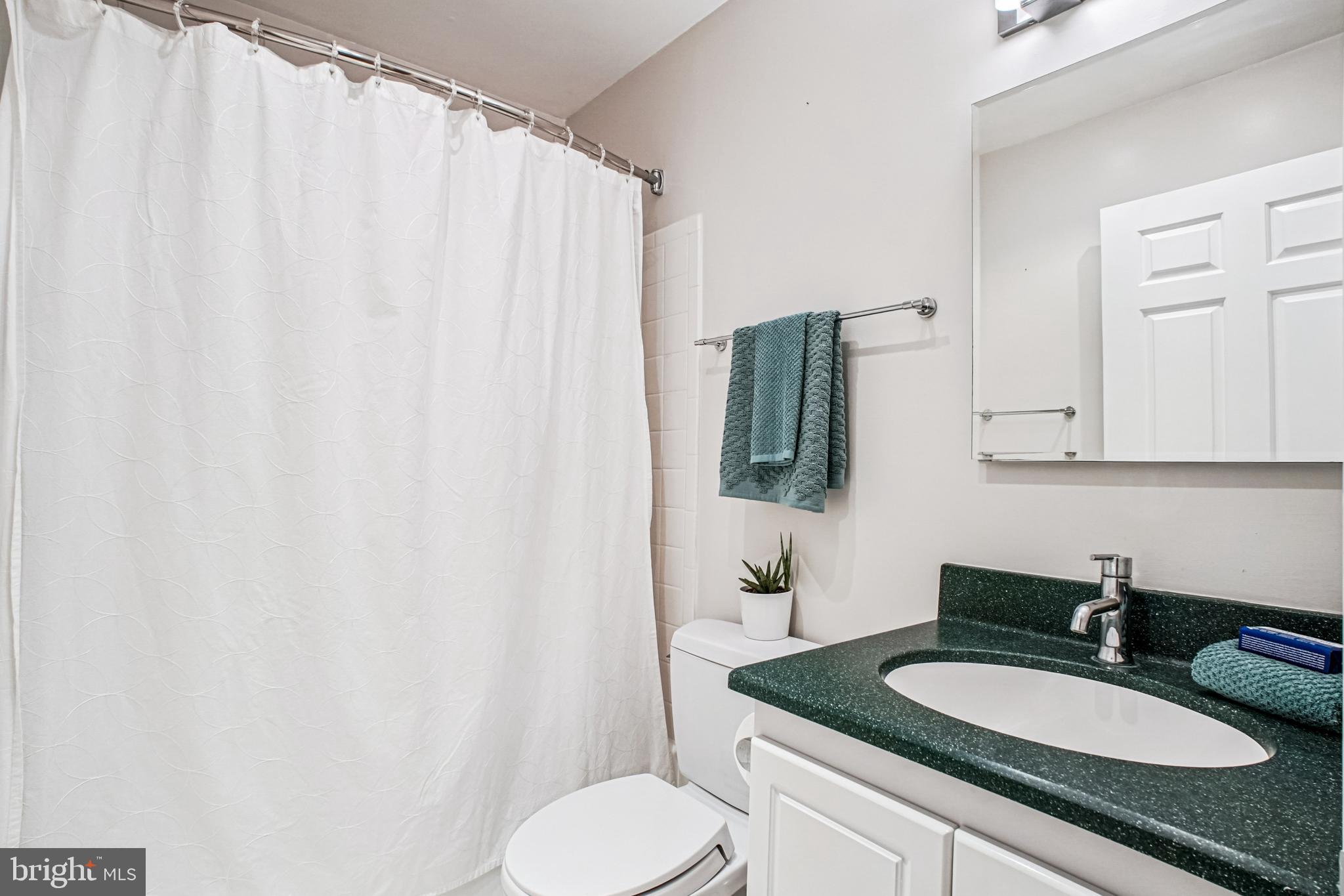 6719 Fairfax Road, Unit 67 Chevy Chase, MD 20815 - Photo 18 of 24 a bathroom with a granite countertop sink and a mirror with toilet