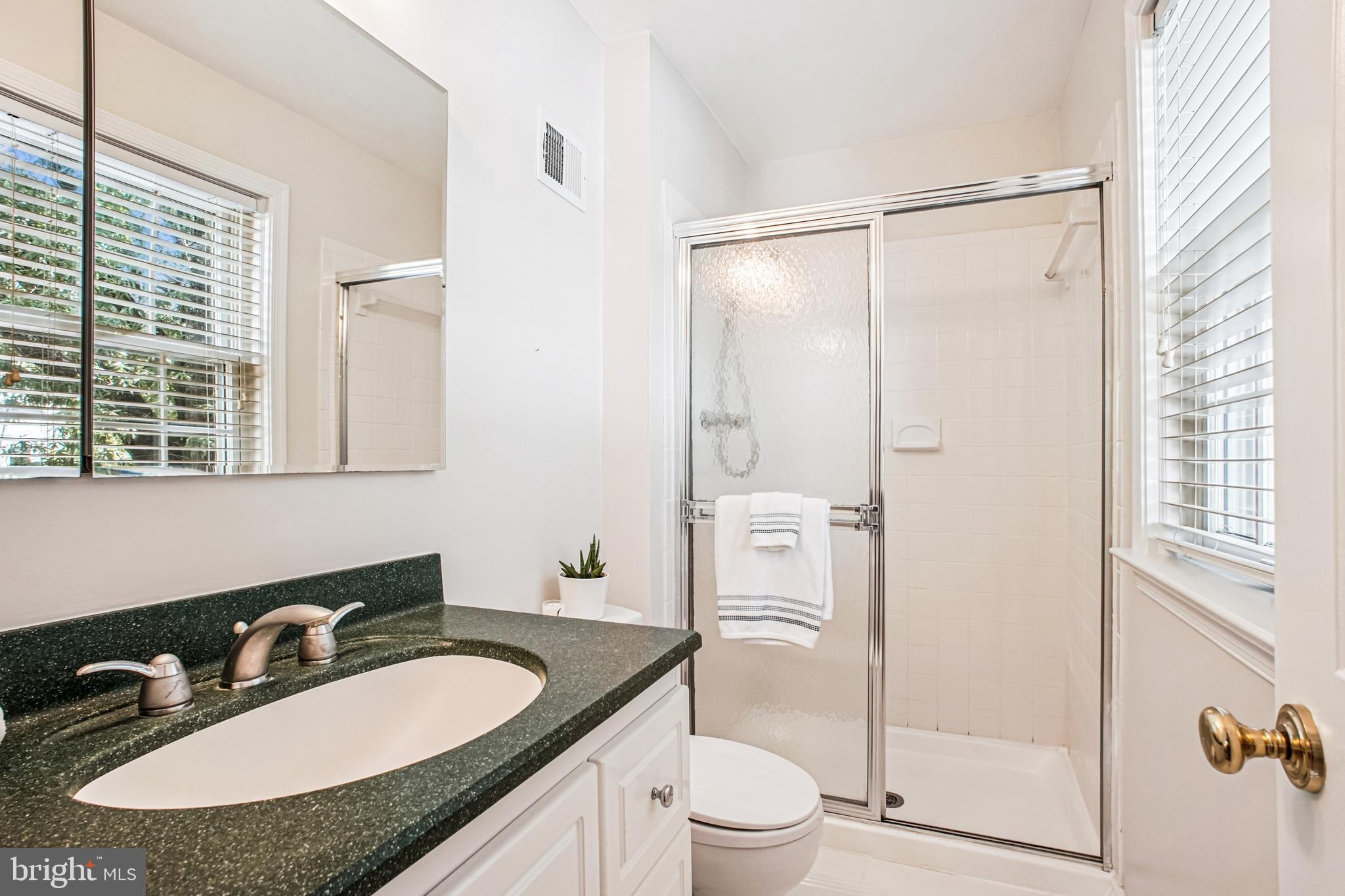 6719 Fairfax Road, Unit 67 Chevy Chase, MD 20815 - Photo 21 of 24 a bathroom with a granite countertop sink mirror vanity and toilet