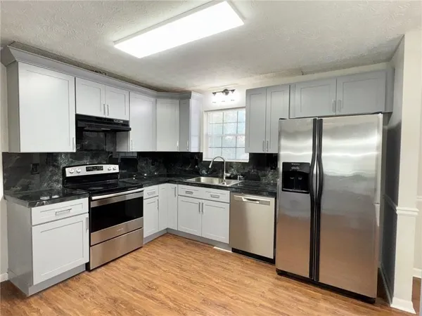 a kitchen with stainless steel appliances granite countertop a stove a refrigerator and a granite counter tops